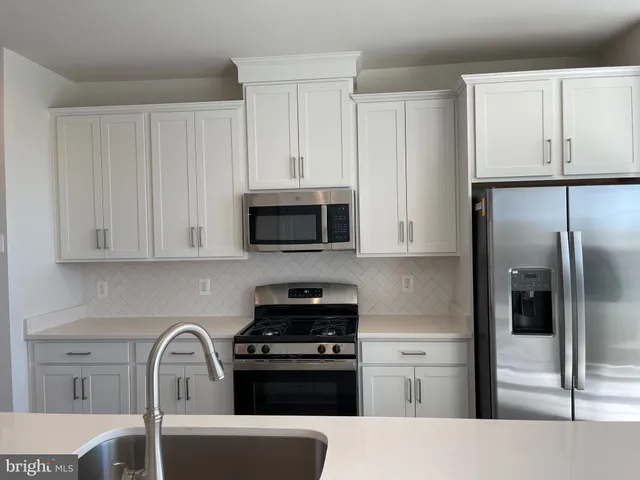 a kitchen with stainless steel appliances granite countertop a refrigerator sink and cabinets