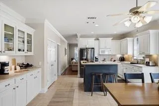 a kitchen with a dining table chairs and a refrigerator