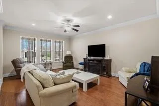 a living room with furniture a flat screen tv and a large window