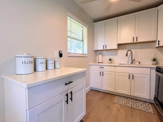 a kitchen with a sink a refrigerator and cabinets