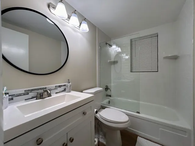 a bathroom with a granite countertop toilet a sink and bathtub
