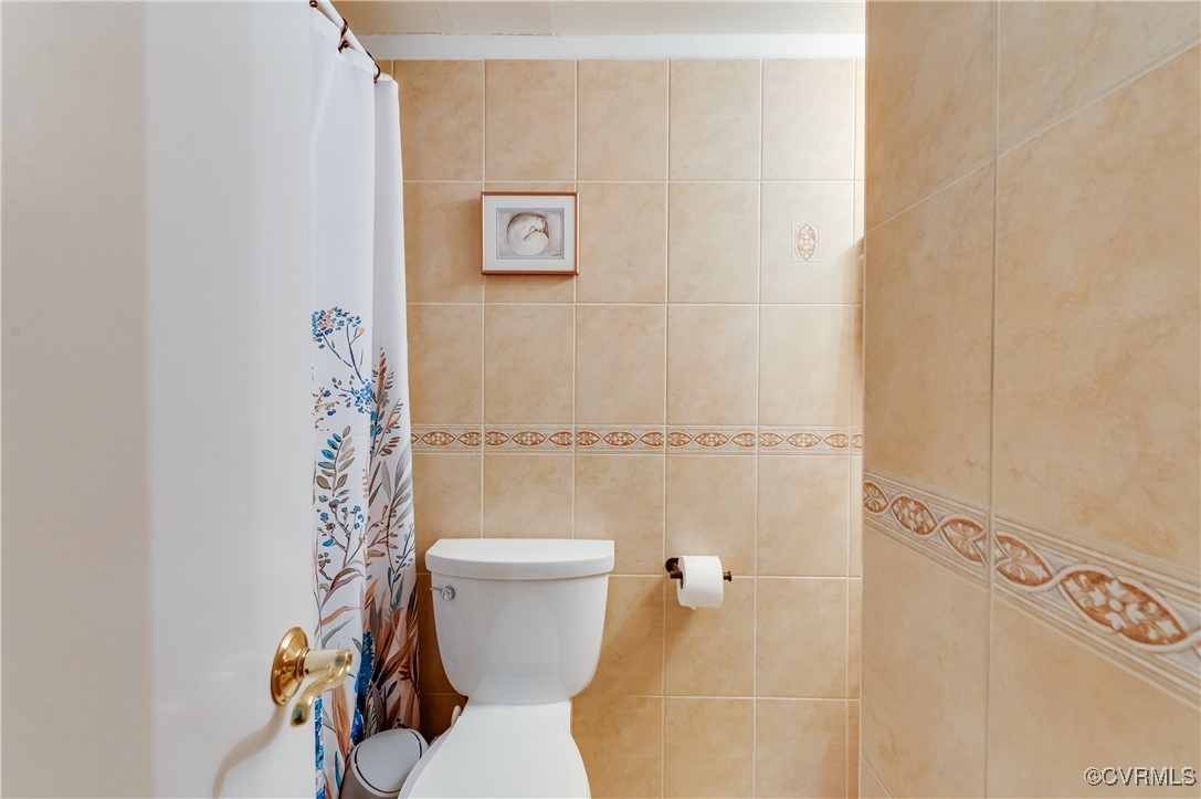 1507 Regency Woods Road, Unit 103 Henrico, VA 23238 - Photo 16 of 32 Bathroom featuring toilet, tile walls, and a showe