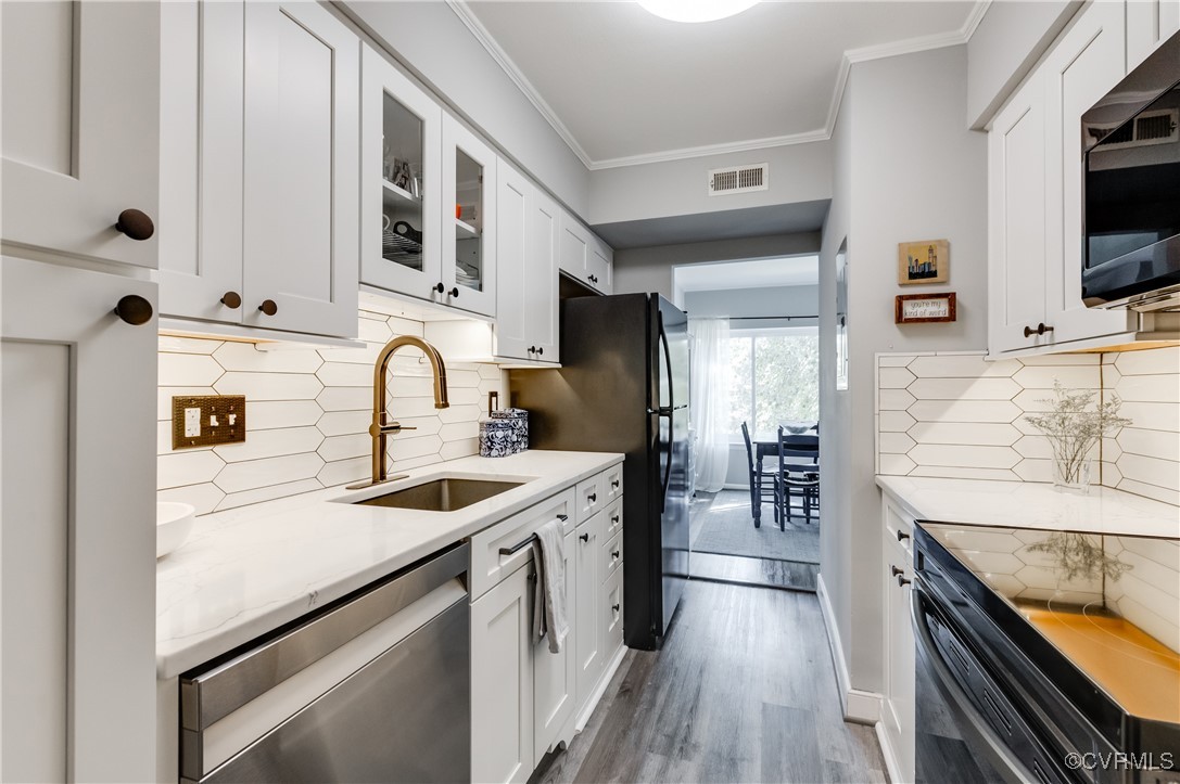 1507 Regency Woods Road, Unit 103 Henrico, VA 23238 - Photo 6 of 32 Kitchen featuring white cabinetry, backsplash, bla