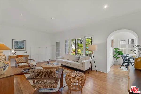 a living room with furniture a rug a lamp and wooden floor