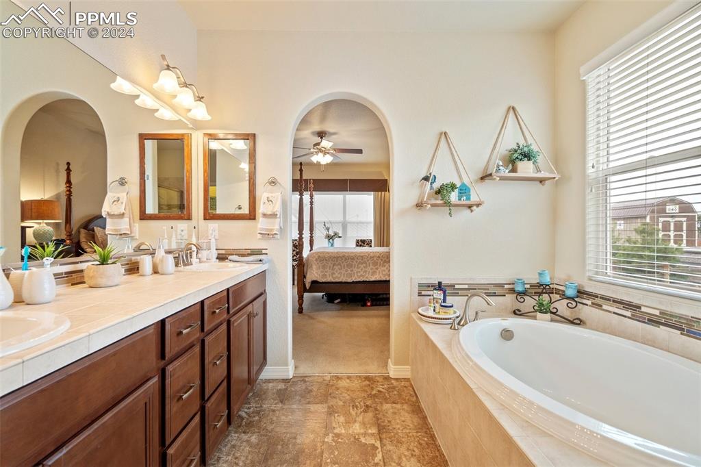 11501 Palmers Green Drive Peyton, CO 80831 - Photo 33 of 49 a en suite bathroom with a double vanity sink and a bathtub