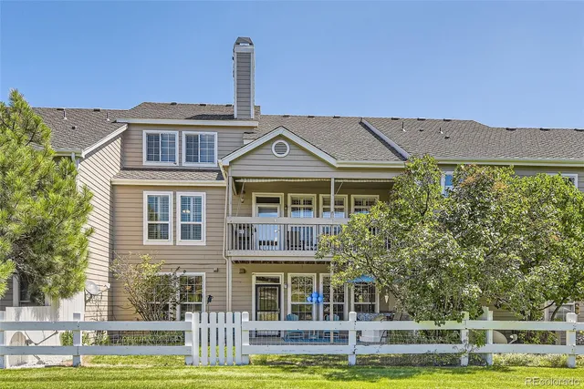 a front view of a house with a garden and lake view