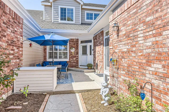 a view of a patio with a table and chairs under an umbrella