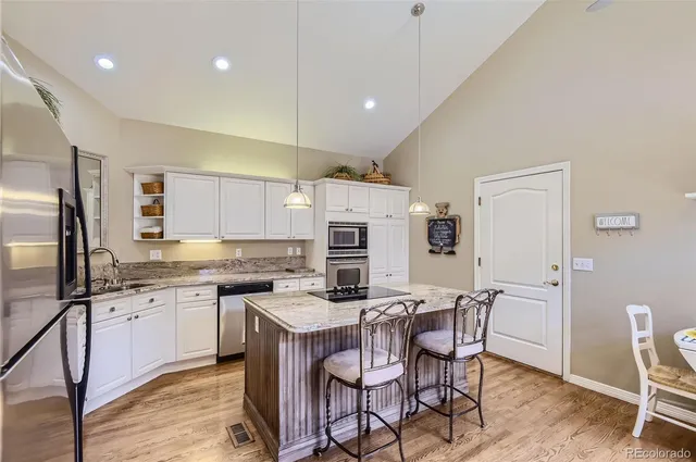 a kitchen with stainless steel appliances kitchen island granite countertop a sink and cabinets