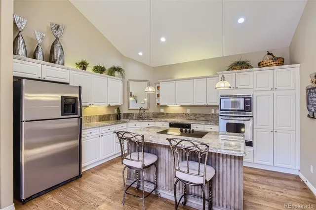 a kitchen with stainless steel appliances a stove a sink a microwave a refrigerator and cabinets