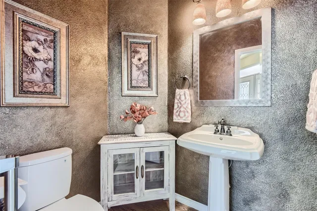 a bathroom with a sink mirror and toilet