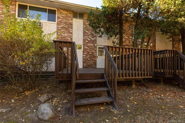 a view of a pathway of a house with a bench wooden floor and fence