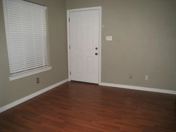 an empty room with wooden floor and closet
