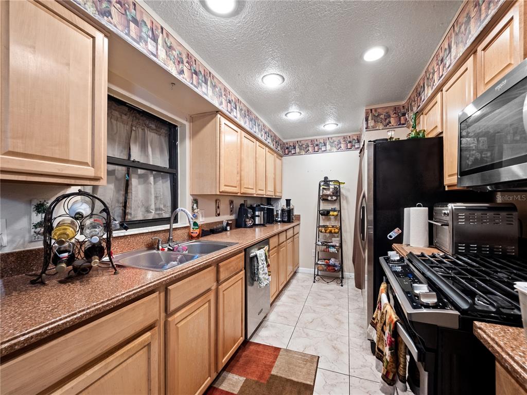 2810 Horton Road Kissimmee, FL 34744 - Photo 13 of 30 a kitchen with stainless steel appliances a sink stove and cabinets