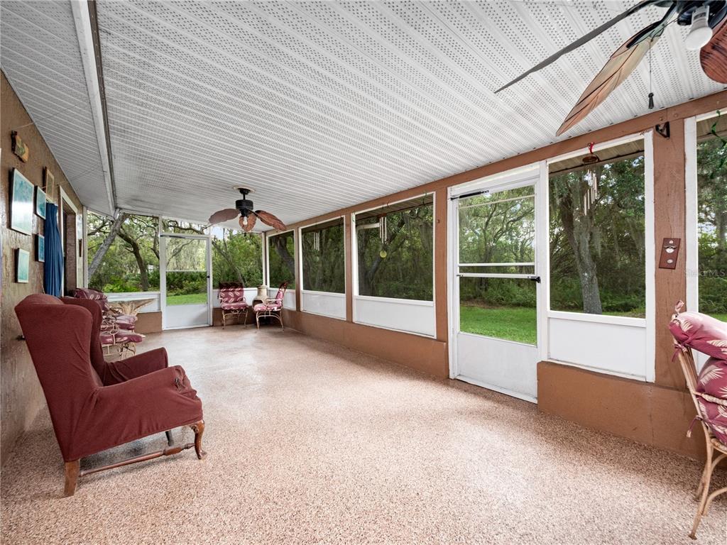 2810 Horton Road Kissimmee, FL 34744 - Photo 23 of 30 a living room with furniture floor to ceiling windows and garden
