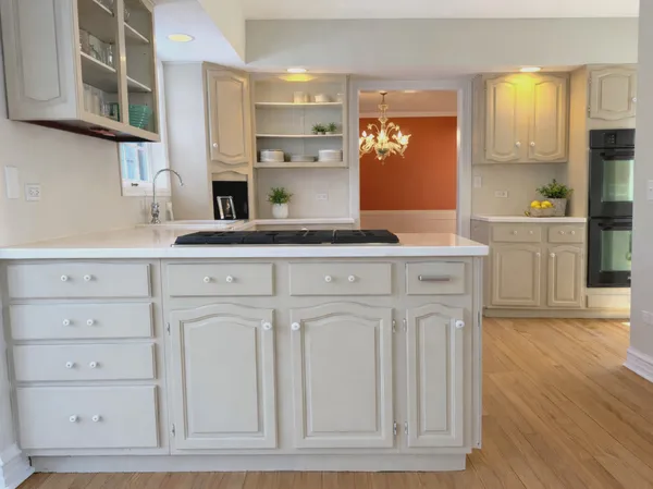 a kitchen with white cabinets and sink