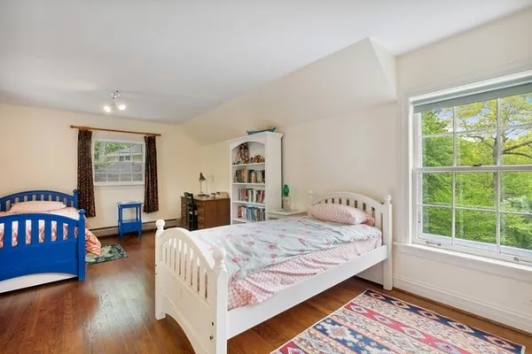 a bedroom with a bed a table and a large window