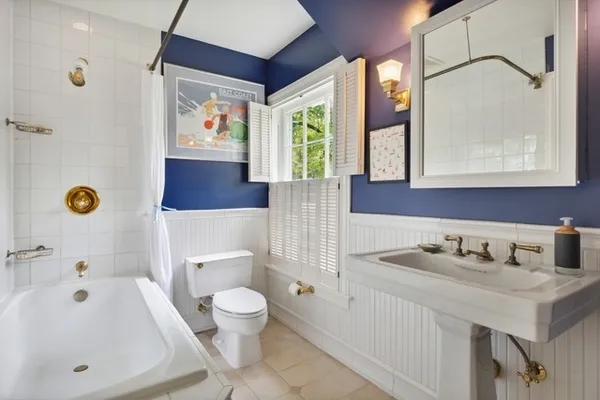 a bathroom with a sink a toilet and shower curtain