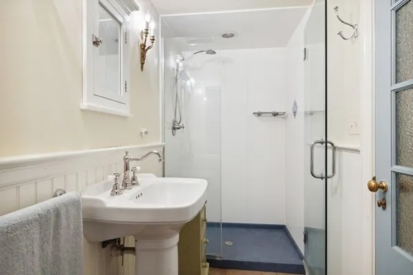 a bathroom with a sink a toilet a mirror and shower