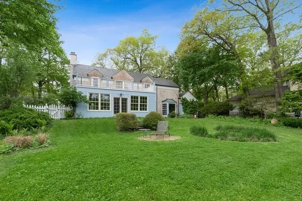 a front view of a house with a yard and trees
