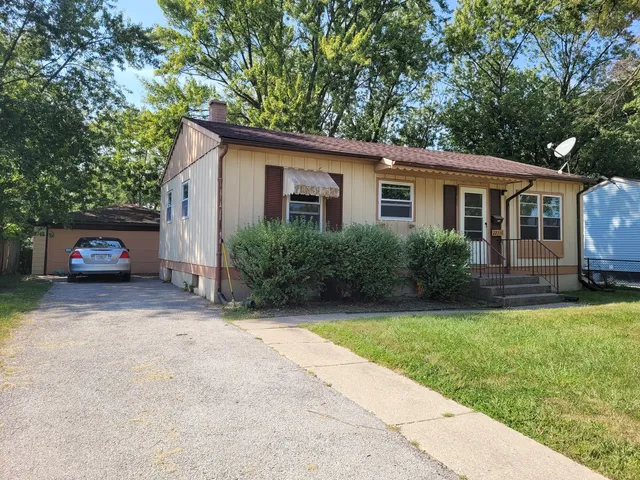 a car parked in front of house with a yard