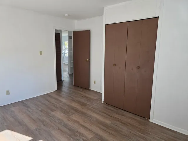 a view of an empty room with wooden floor