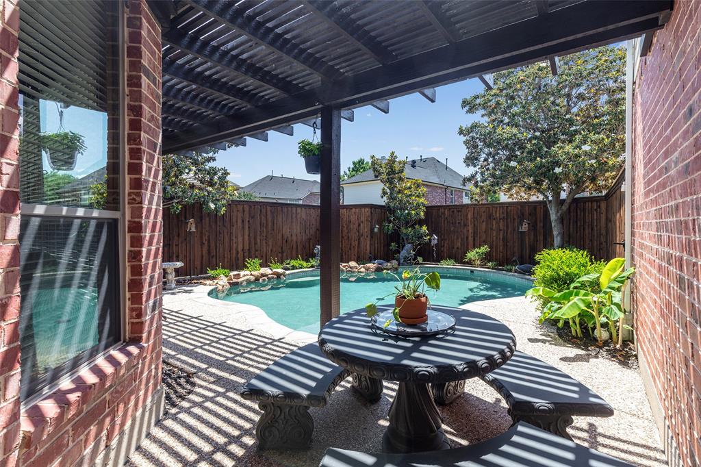 1217 Windmere Way Allen, TX 75013 - Photo 5 of 38 Beneath the shaded pergola, this intimate patio setting invites slow mornings, evening conversations, and effortless outdoor dining beside the pool.