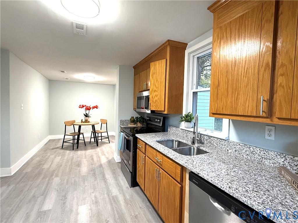 1748 Youngs Road Petersburg, VA 23803 - Photo 12 of 25 Kitchen with brown cabinets, light stone counterto