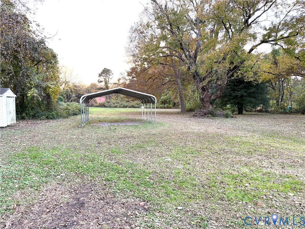 1748 Youngs Road Petersburg, VA 23803 - Photo 24 of 25 View of green lawn featuring a carport and a stora