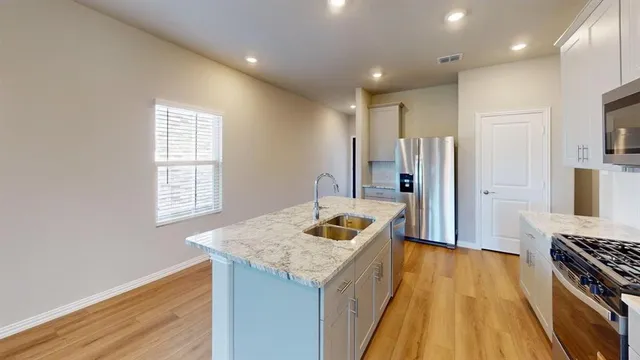 a kitchen with stainless steel appliances granite countertop a sink stove and refrigerator