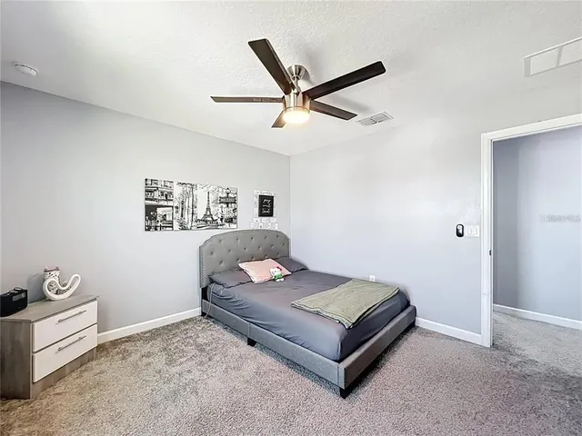 a bedroom with a bed and a ceiling fan