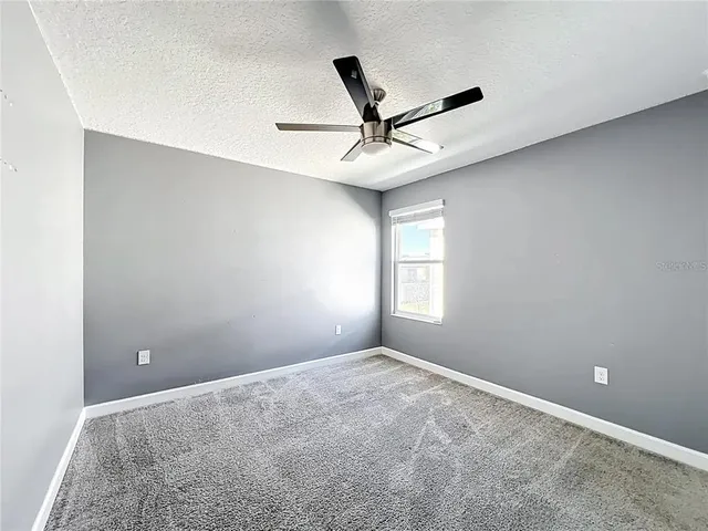 a view of room with a ceiling fan and window