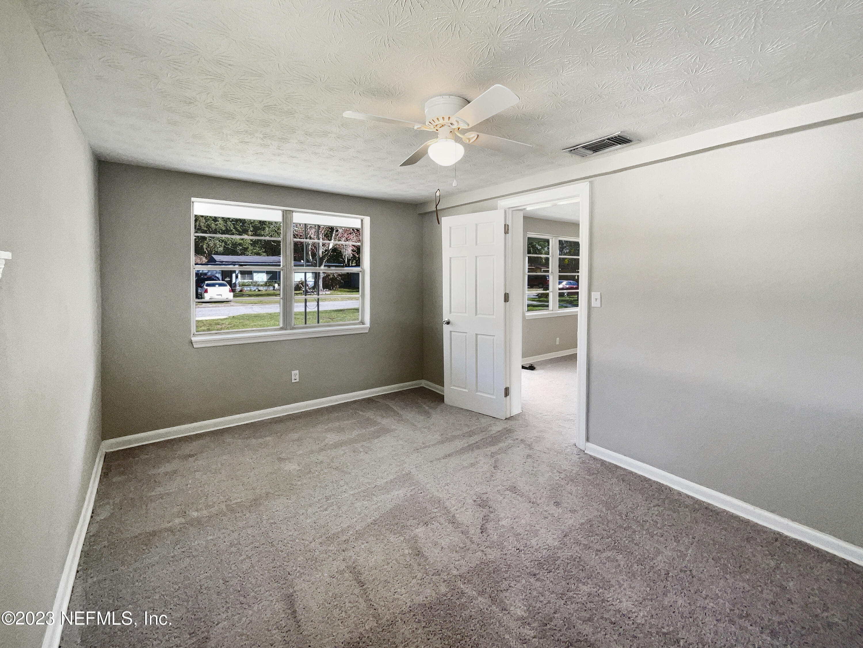 5624 Orangewood Road Jacksonville, FL 32207 - Photo 11 of 19 an empty room with windows and ceiling fan