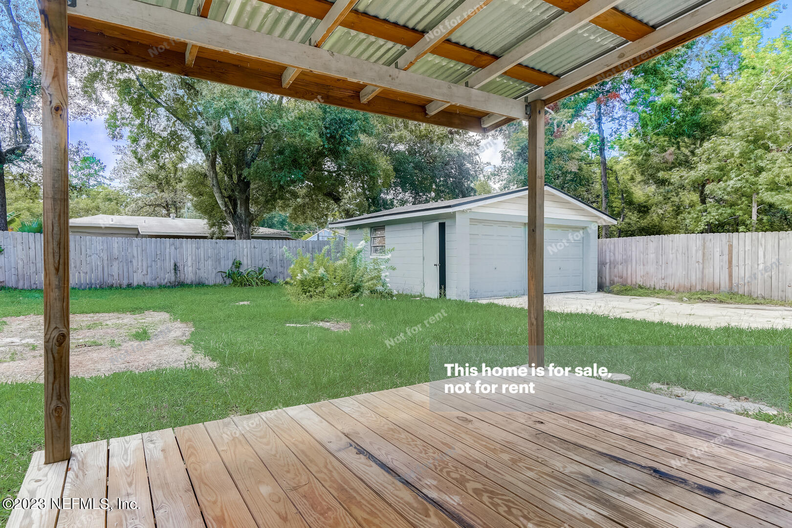 5624 Orangewood Road Jacksonville, FL 32207 - Photo 17 of 19 a view of a backyard with plants and large trees with wooden fence