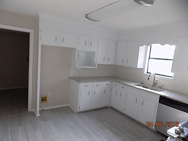 6340 Britt Road Macon, GA 31216 - Photo 8 of 21 a kitchen with a sink dishwasher and white cabinets with wooden floor