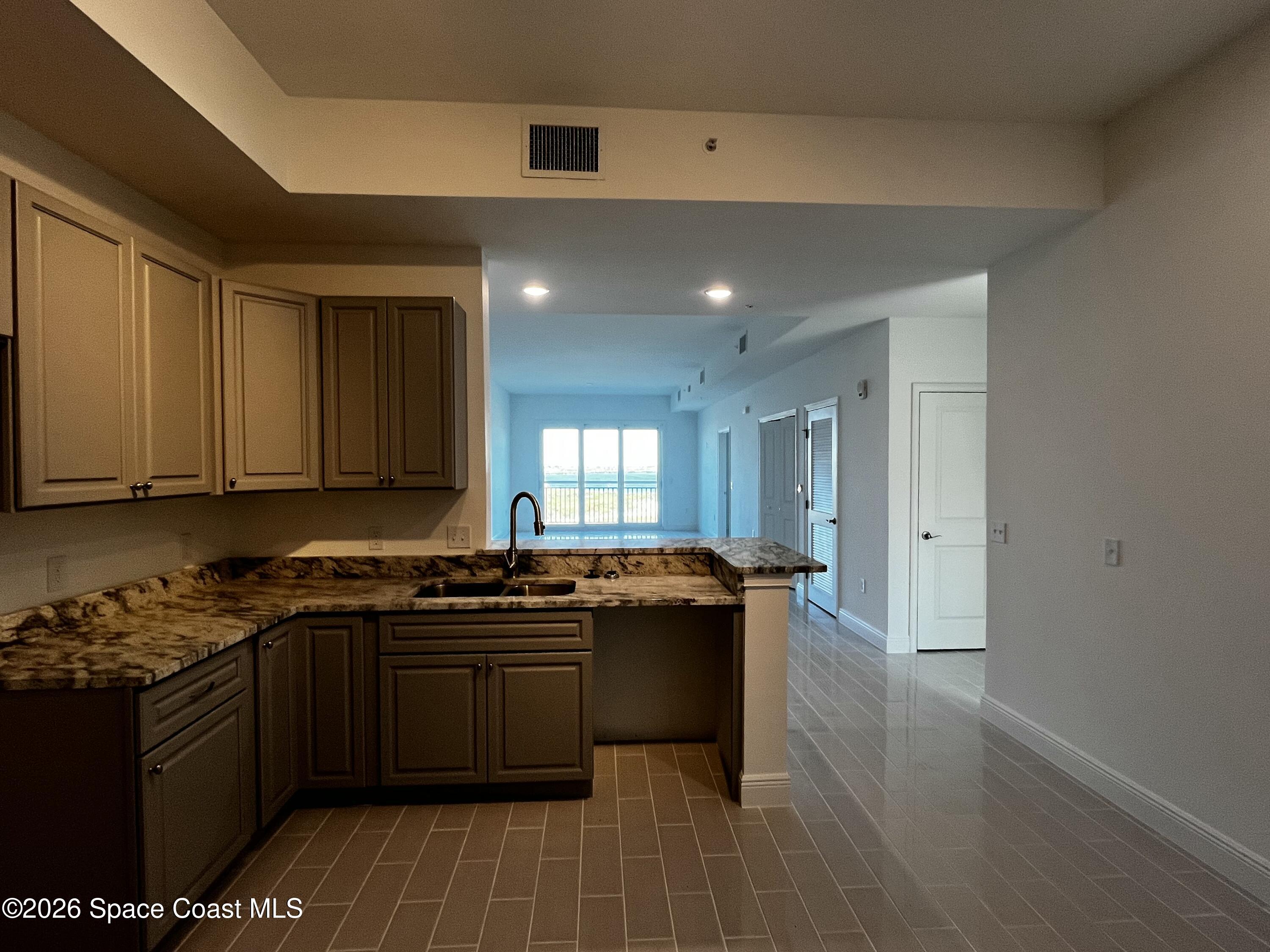 735 Pilot Lane, Unit 1009 Merritt Island, FL 32952 - Photo 4 of 21 a kitchen with a sink a stove and cabinets
