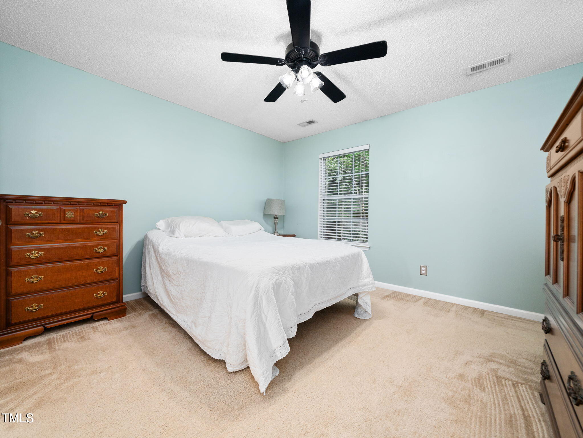 209 Climbing Ivy Court Cary, NC 27511 - Photo 13 of 24 a bedroom with a bed and a ceiling fan