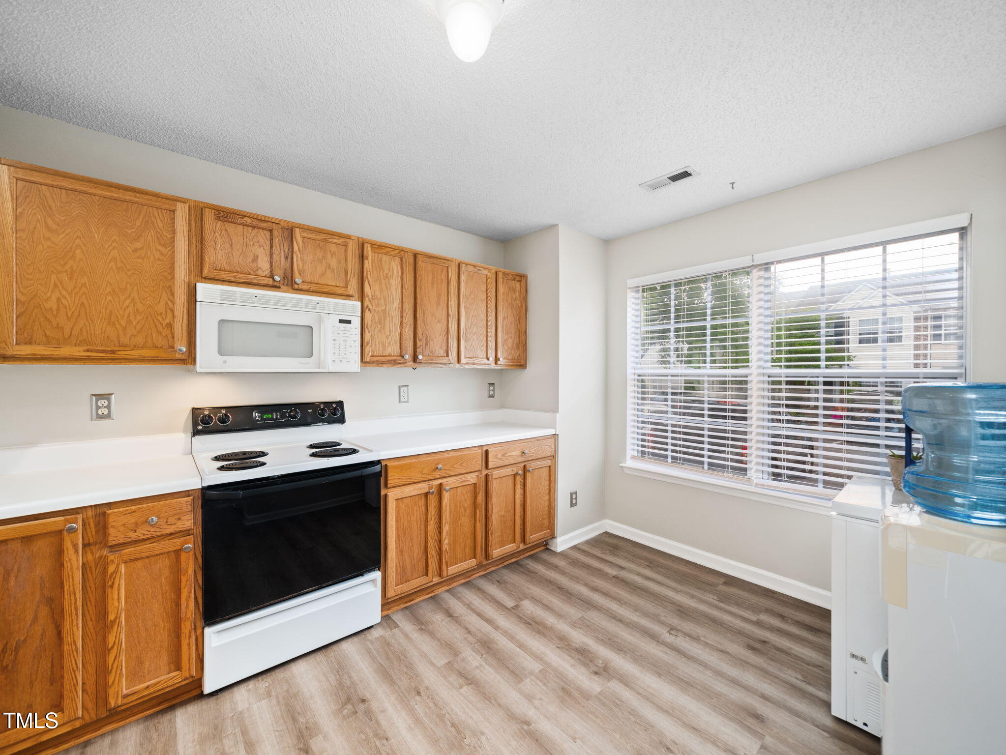 209 Climbing Ivy Court Cary, NC 27511 - Photo 8 of 24 a kitchen with stainless steel appliances granite countertop a stove a sink and a microwave
