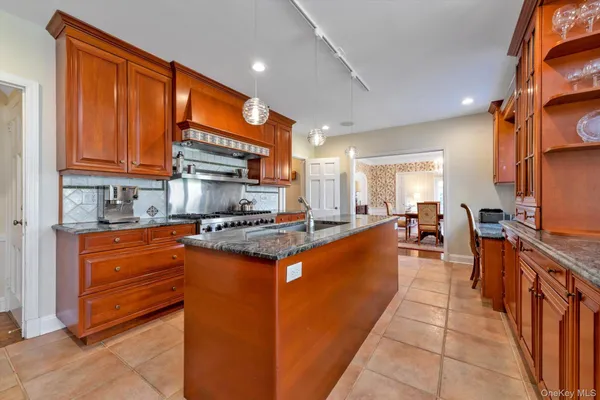 a large kitchen with stainless steel appliances granite countertop a stove a sink dishwasher and a refrigerator