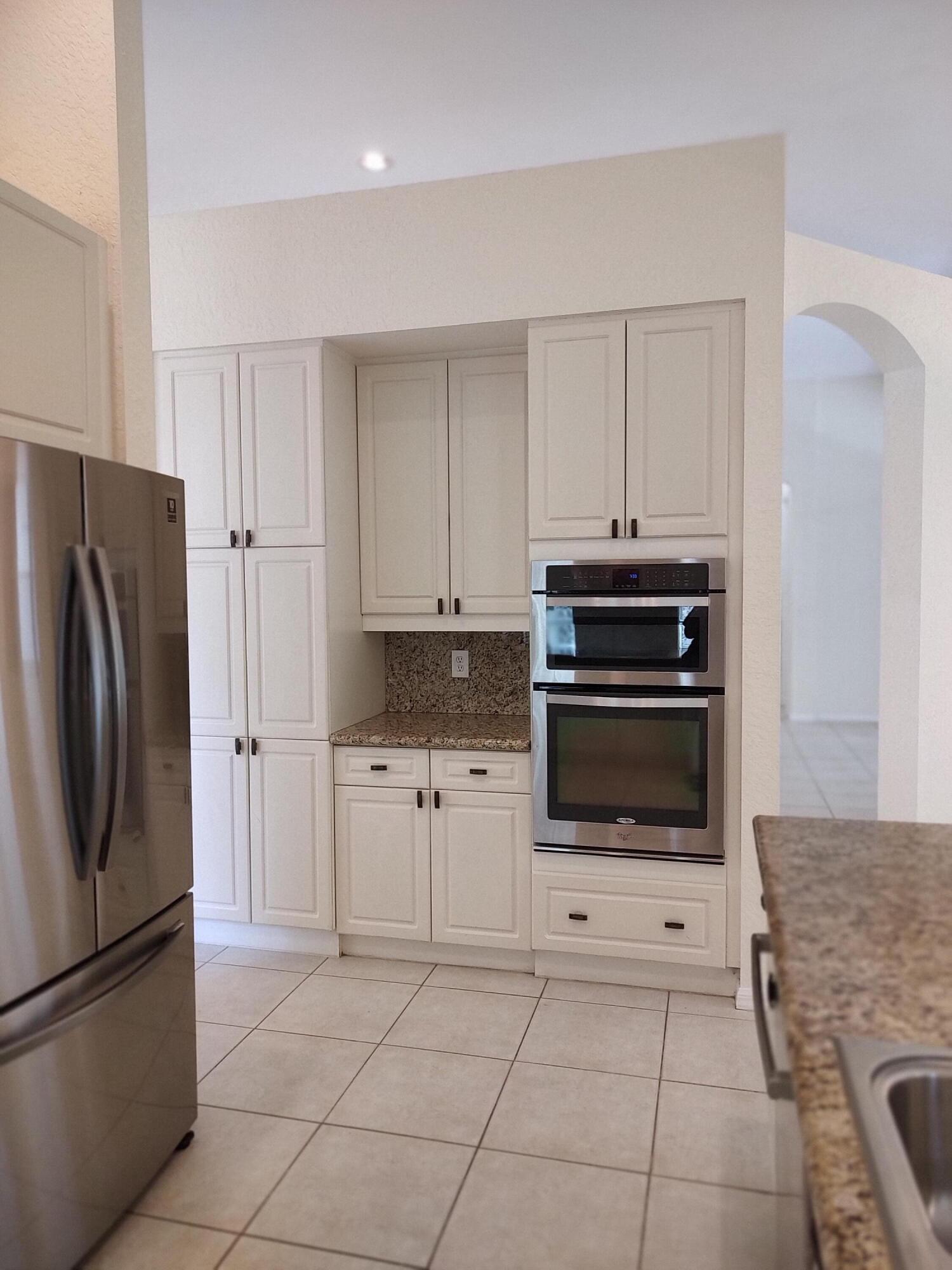 11241 Sea Grass Circle Boca Raton, FL 33498 - Photo 8 of 33 a kitchen with granite countertop a refrigerator and a stove top oven