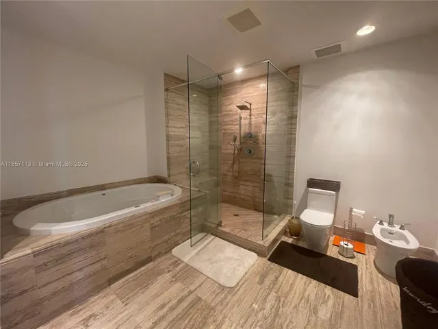 a bathroom with a bathtub a toilet a sink and shower