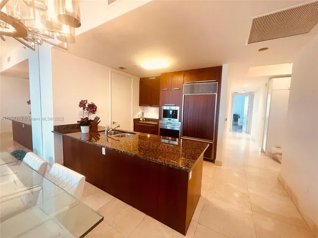 a kitchen with stainless steel appliances granite countertop a refrigerator and a sink