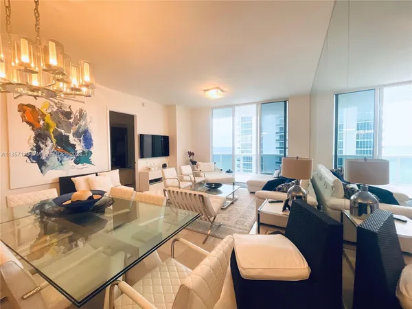 a living room with furniture a flat screen tv and a large window
