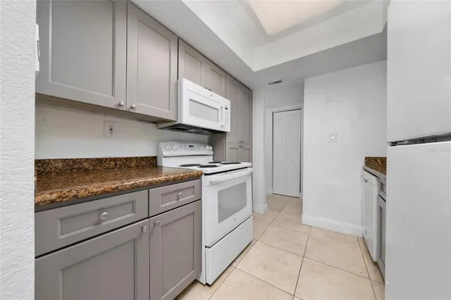 a kitchen with white cabinets and white appliances