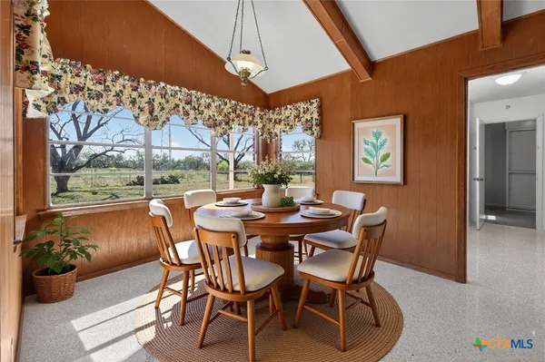 a dining room with furniture and a floor to ceiling window