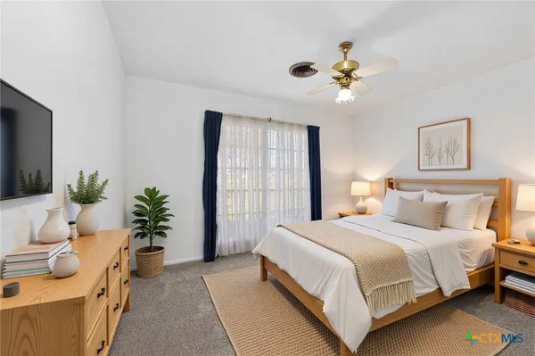 a bedroom with a large bed and a chandelier