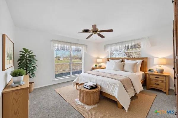 a spacious bedroom with a bed and a potted plant