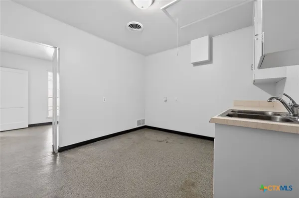 a view of a storage & utility room with a sink
