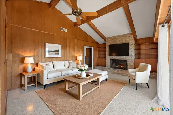 a living room with furniture a flat screen tv and a fireplace