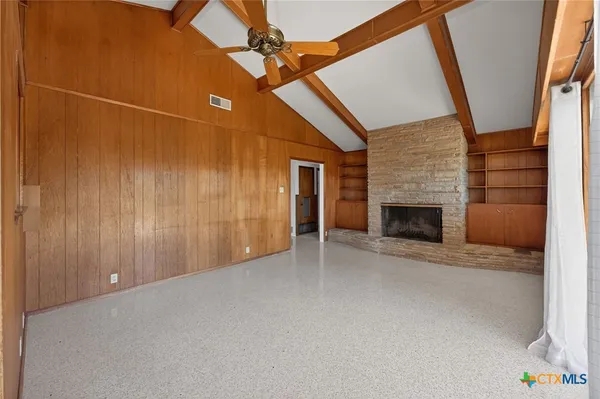 a view of empty room with fireplace and fan