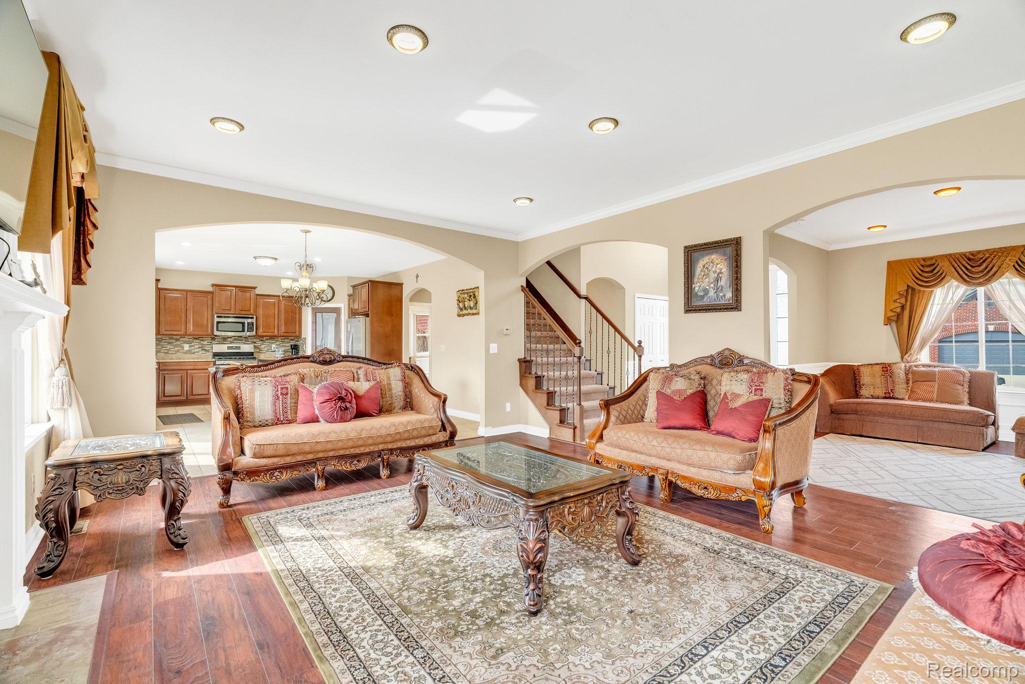 4122 Hawks Nest Road Utica, MI 48317 - Photo 21 of 74 Living room featuring arched walkways, crown molding, light wood-style floors, and suspended lighting